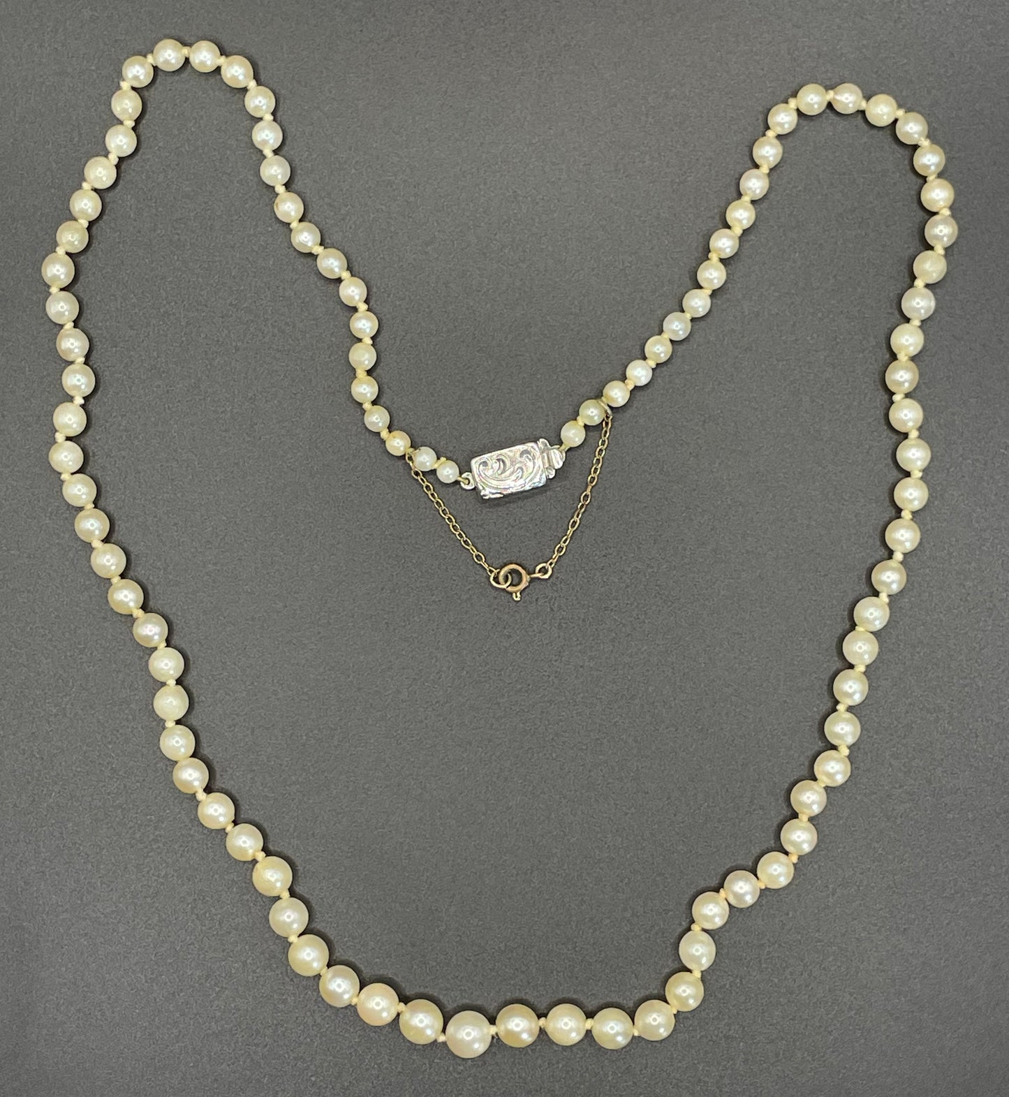 Vintage real cultured pearl necklace, graduated in size, hand-knotted, pretty engraved sterling silver clasp, mid-length