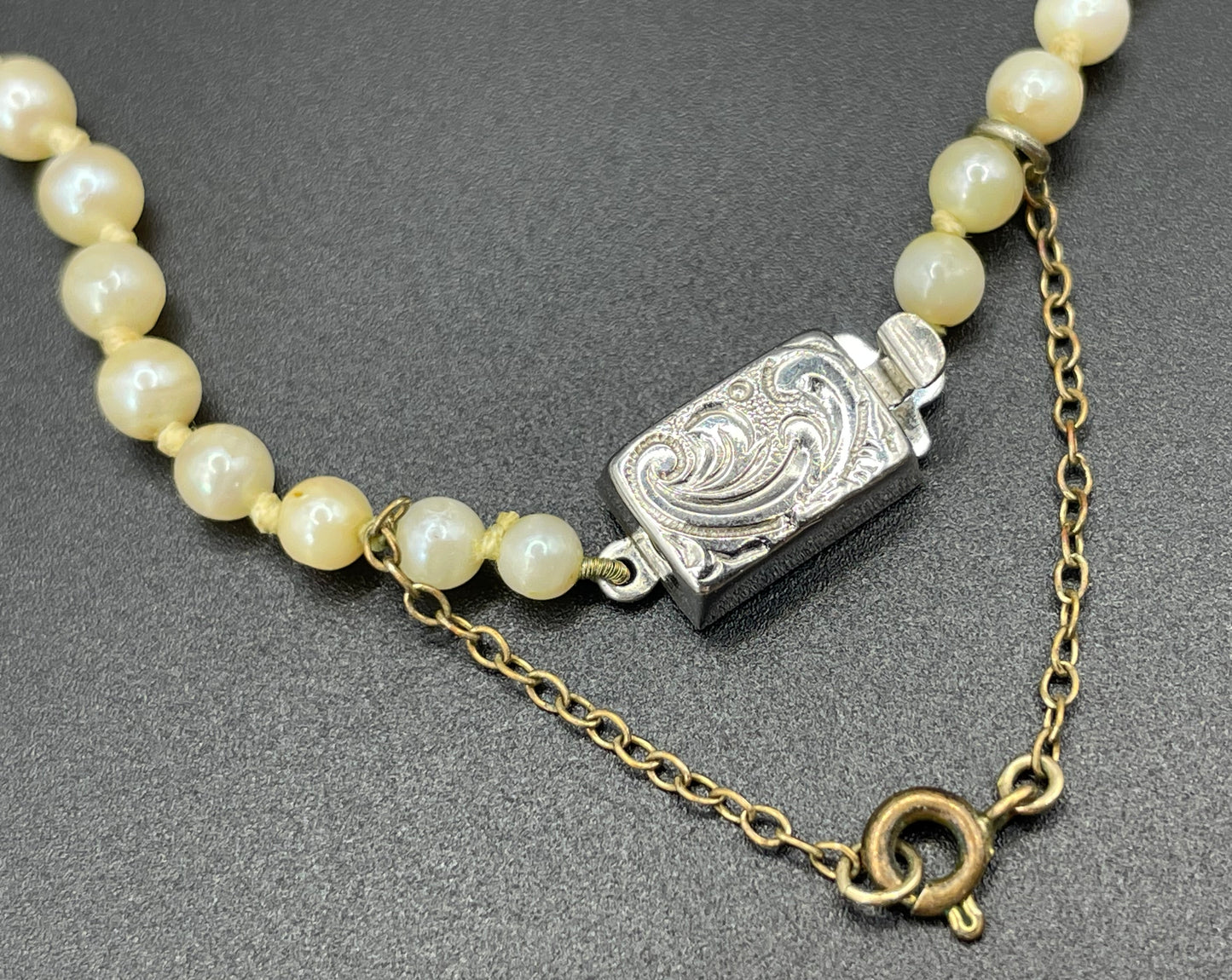 Vintage real cultured pearl necklace, graduated in size, hand-knotted, pretty engraved sterling silver clasp, mid-length