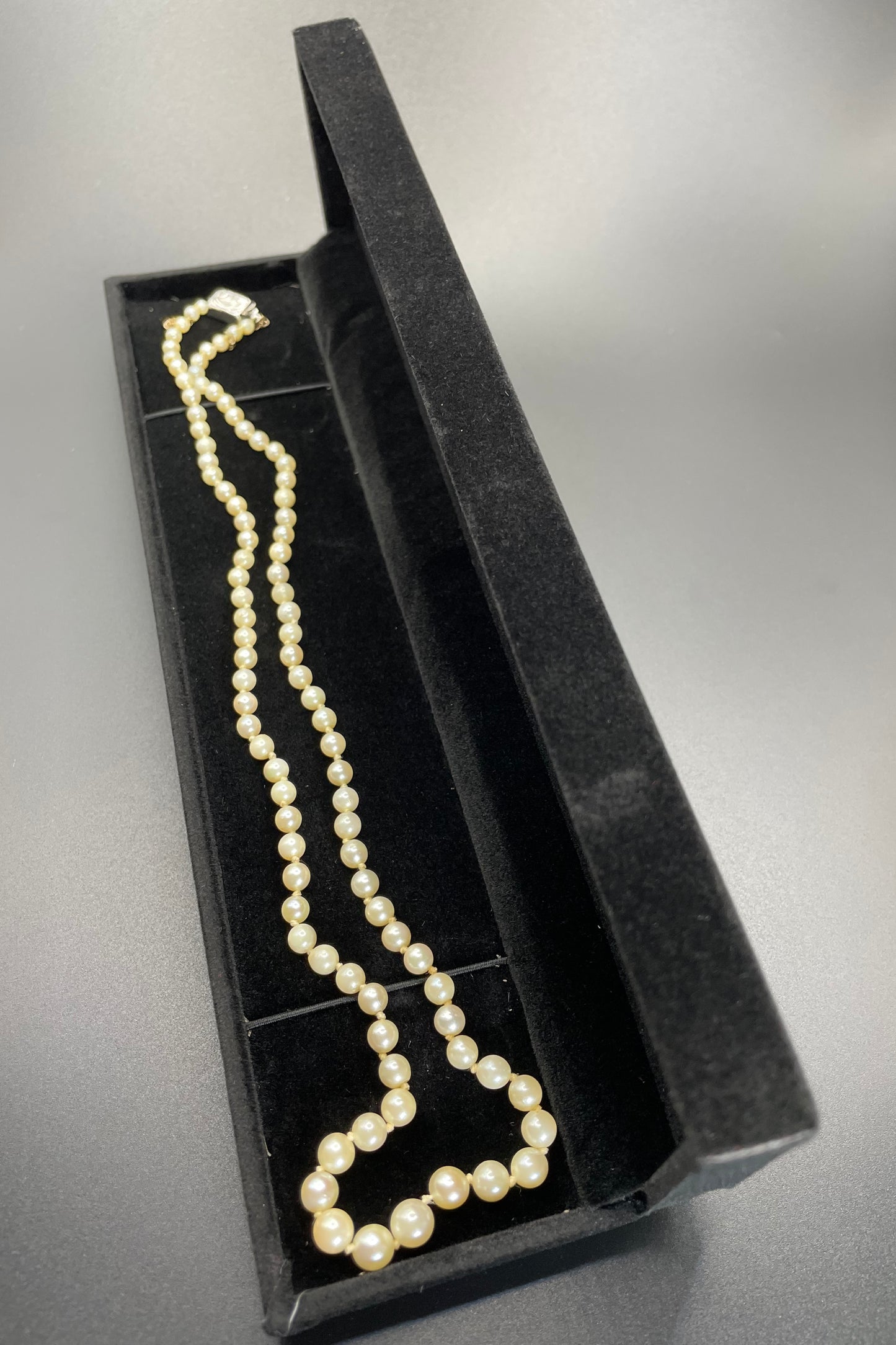 Vintage real cultured pearl necklace, graduated in size, hand-knotted, pretty engraved sterling silver clasp, mid-length