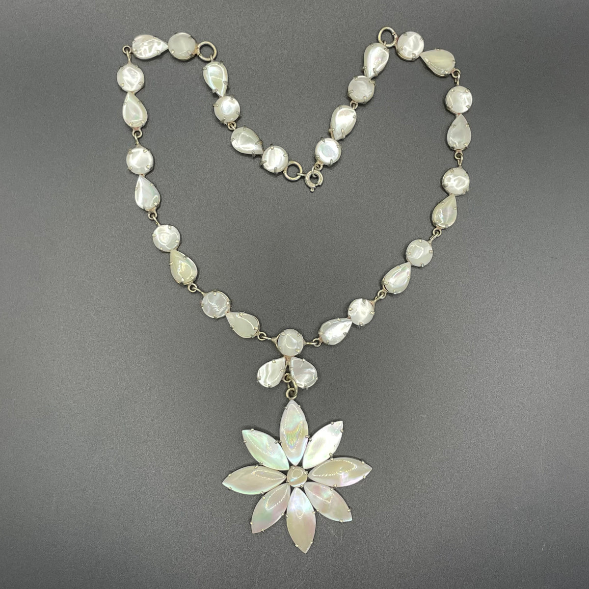 Antique / vintage mother of pearl riviere necklace, open backed pale gold tone settings, beautiful MOP cabochons, large floral pendant drop