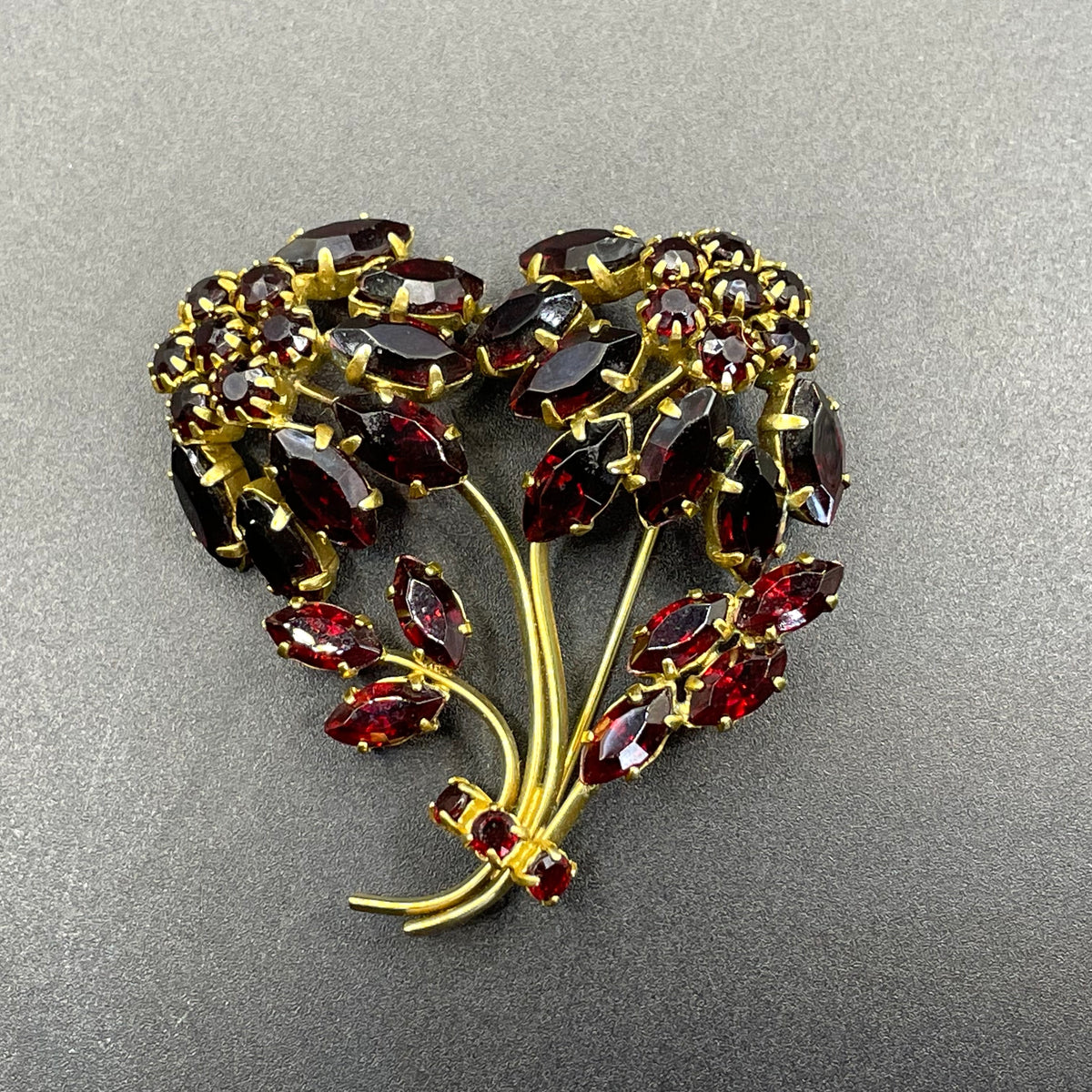 Vintage red garnet glass flower bouquet brooch, with rhinestones set open-backed in gold tone