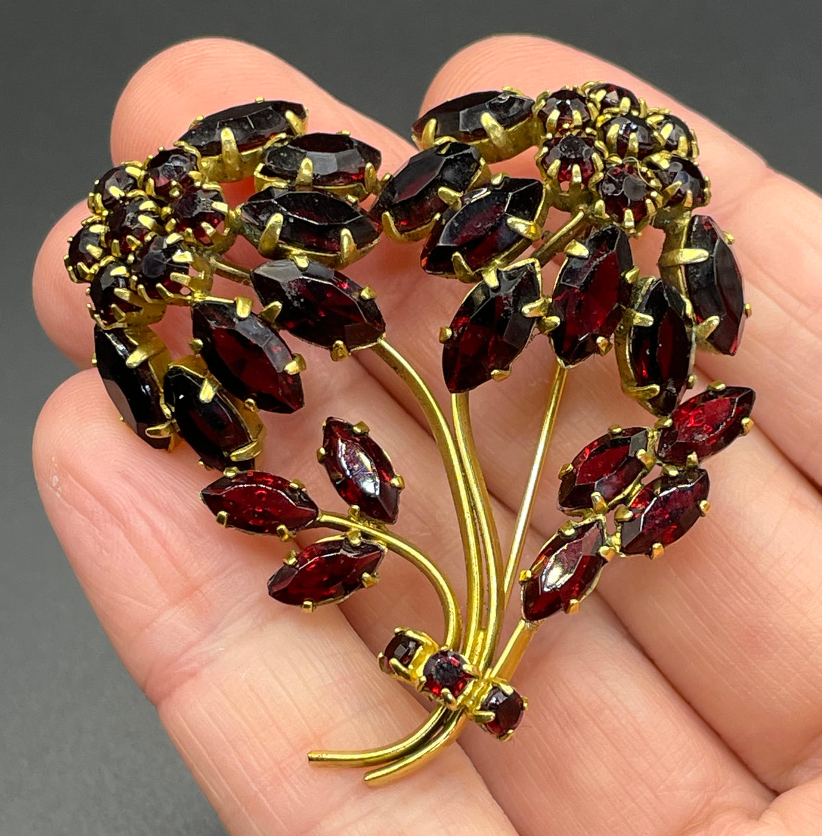 Vintage red garnet glass flower bouquet brooch, with rhinestones set open-backed in gold tone