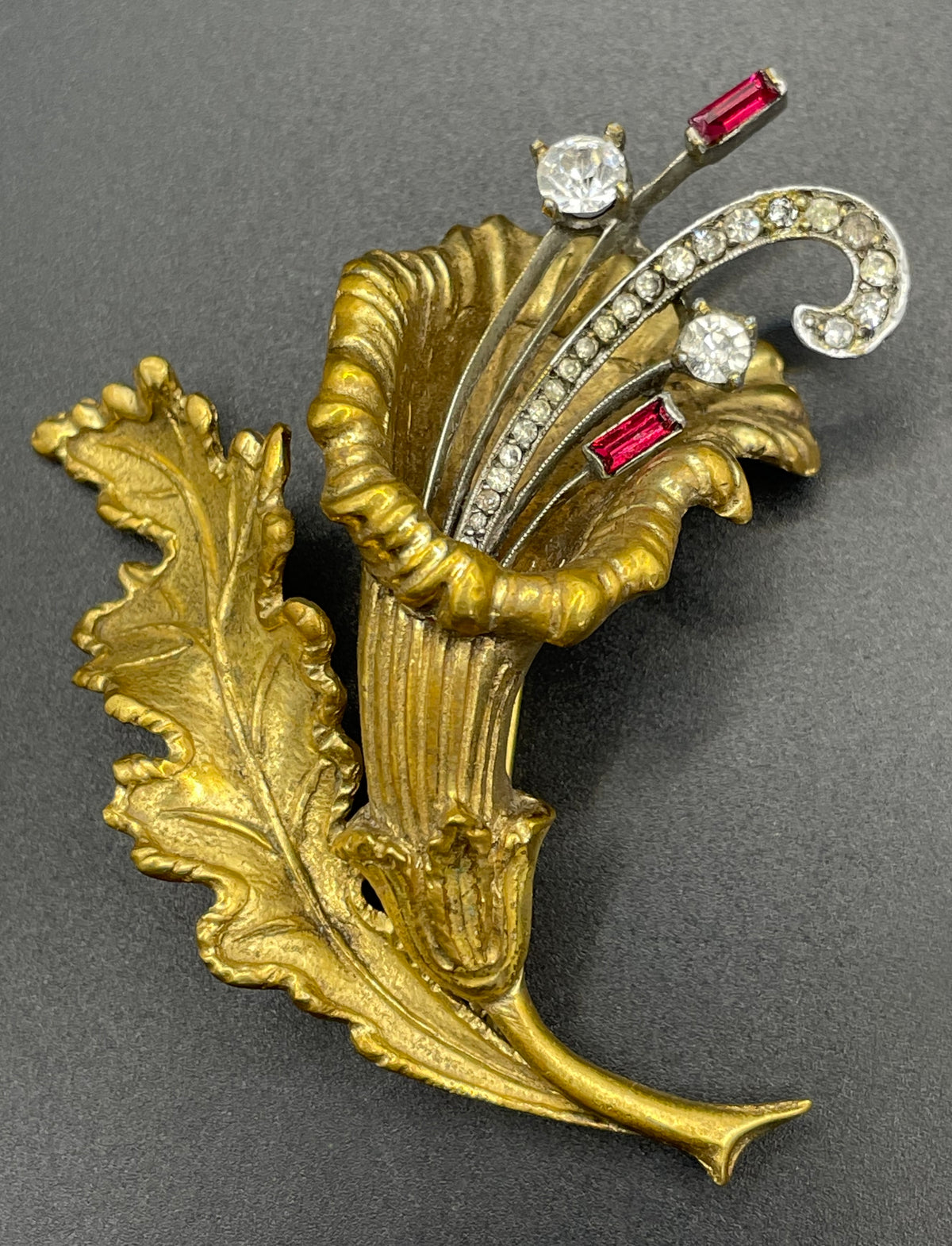 Vintage lily flower and leaf design DeRosa style brooch in gold and silver tone with clear and red rhinestones