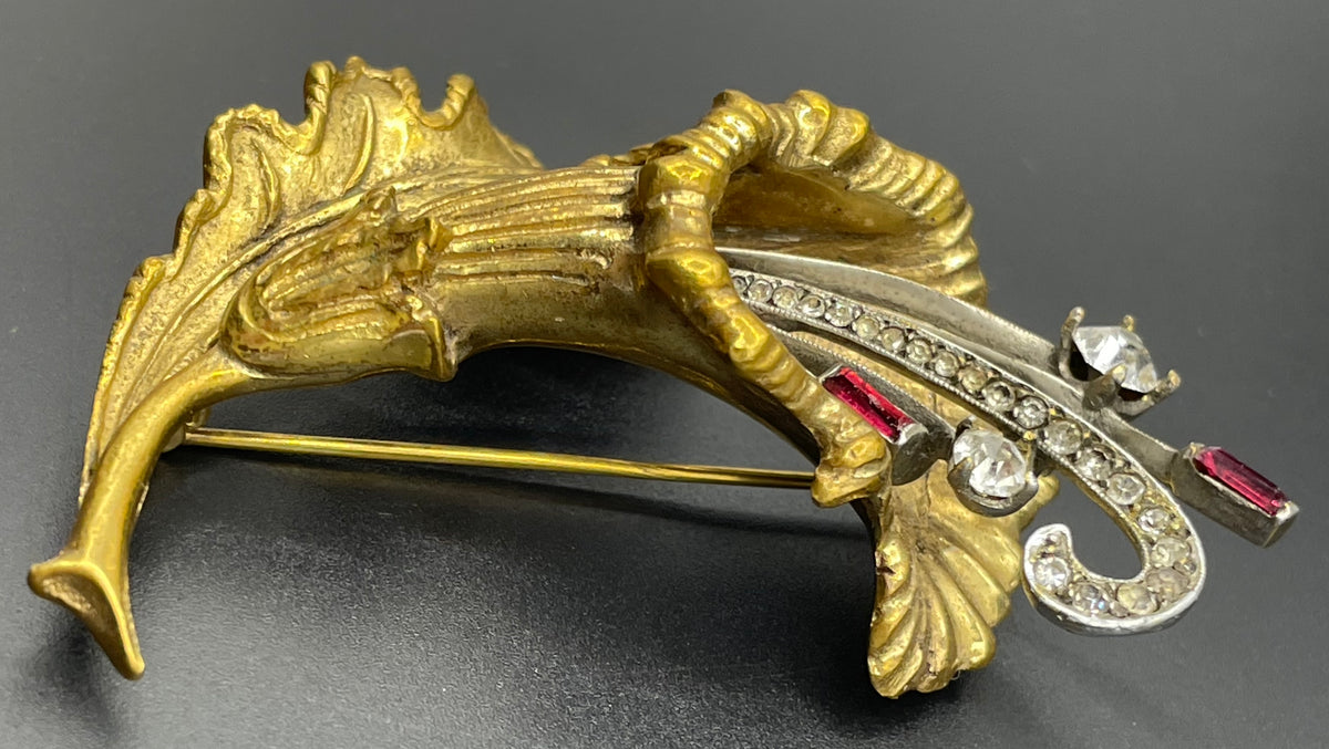 Vintage lily flower and leaf design DeRosa style brooch in gold and silver tone with clear and red rhinestones