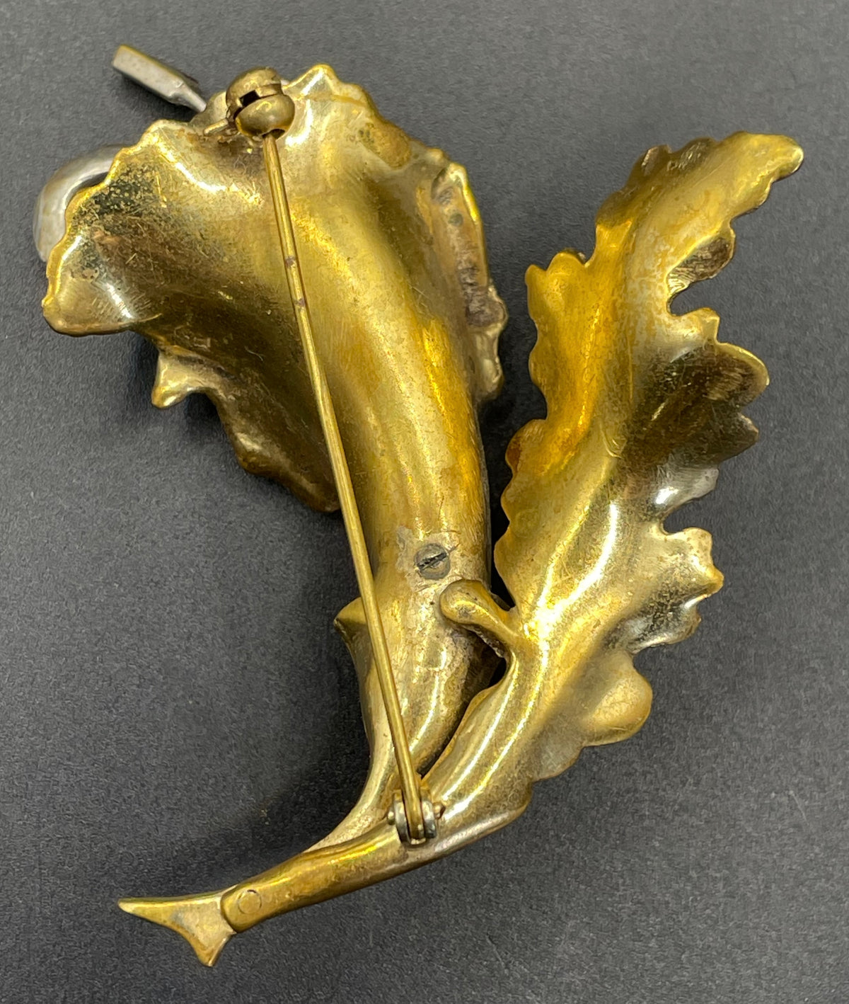 Vintage lily flower and leaf design DeRosa style brooch in gold and silver tone with clear and red rhinestones