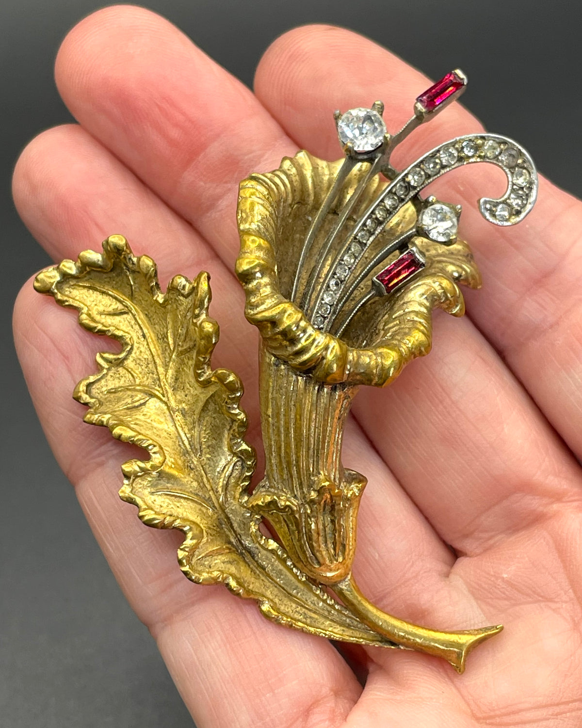 Vintage lily flower and leaf design DeRosa style brooch in gold and silver tone with clear and red rhinestones