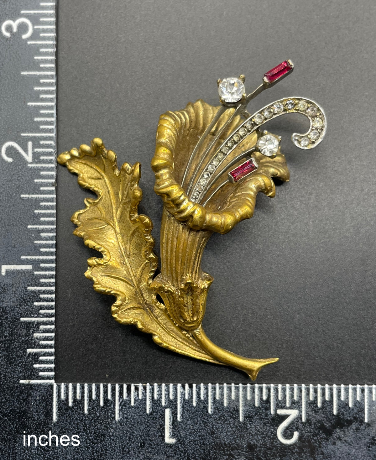 Vintage lily flower and leaf design DeRosa style brooch in gold and silver tone with clear and red rhinestones