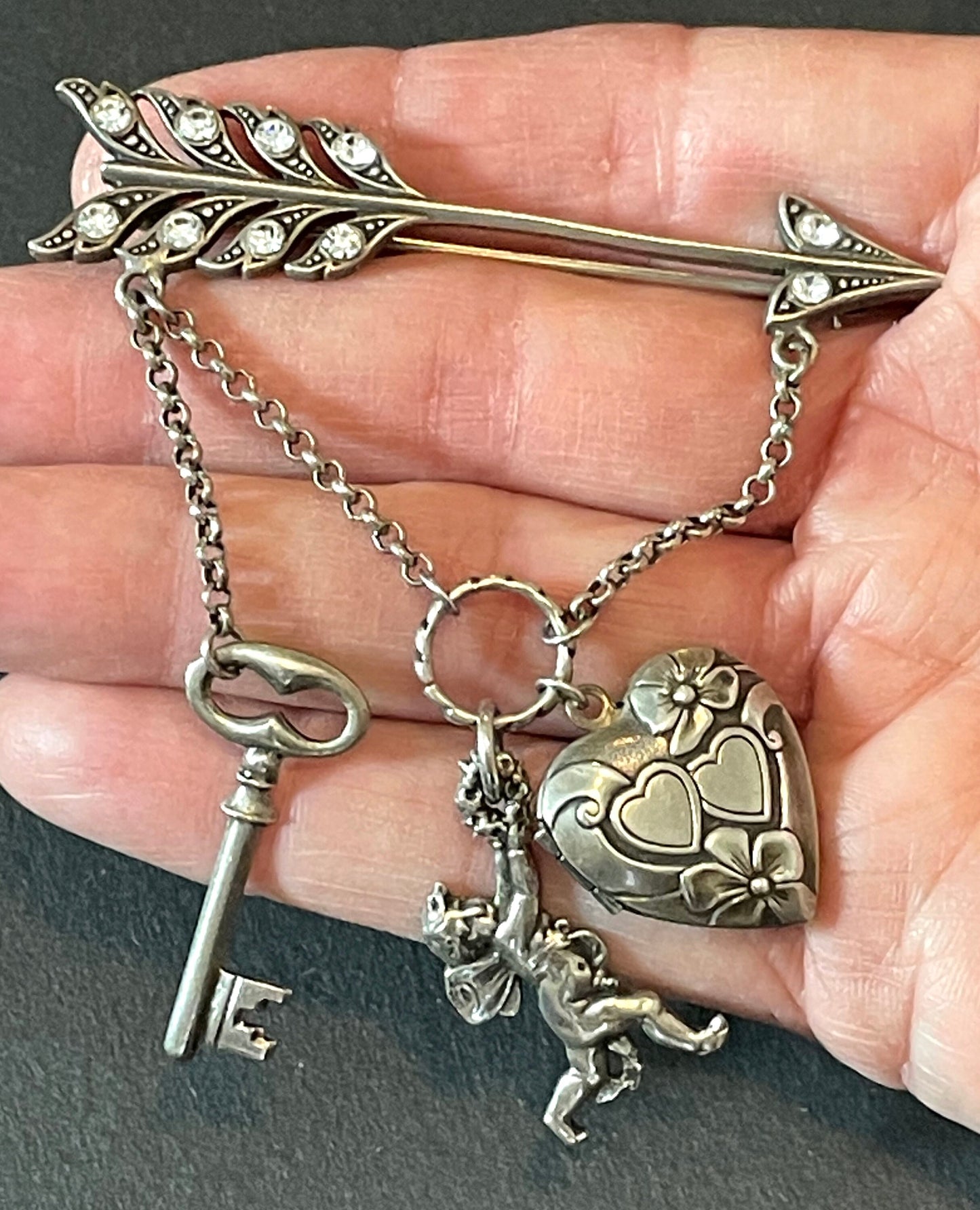 Large early Askew London, vintage cupid's arrow love brooch in antique silver tone with rhinestones, cherub, heart locket and key