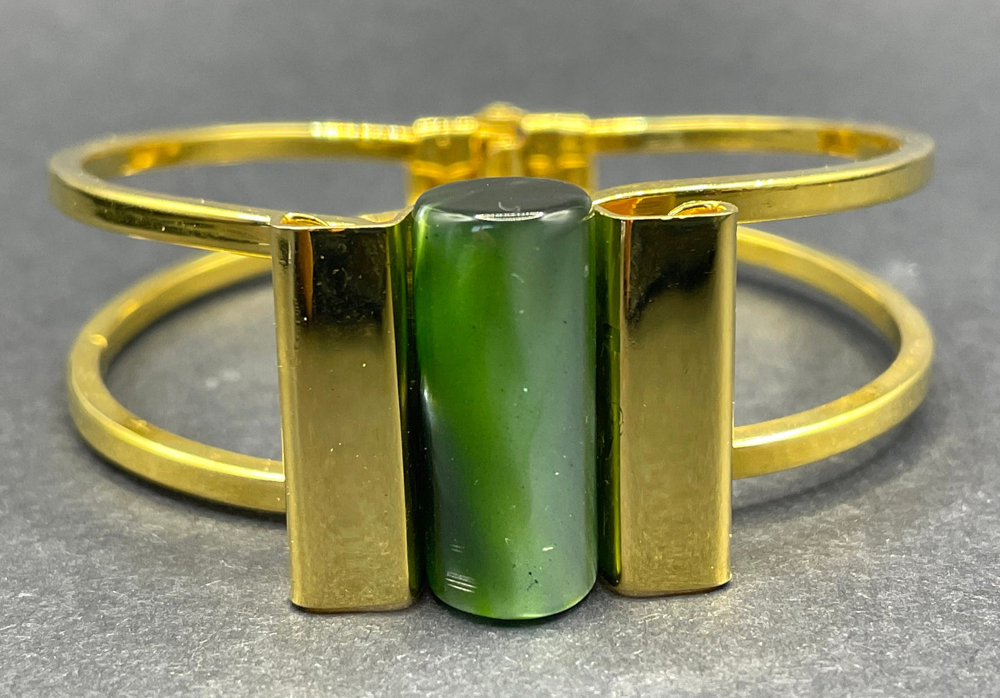 Vintage Jakob Bengel Art Deco machine age clamper bangle in shiny gold tone with a rich green galalith cylinder