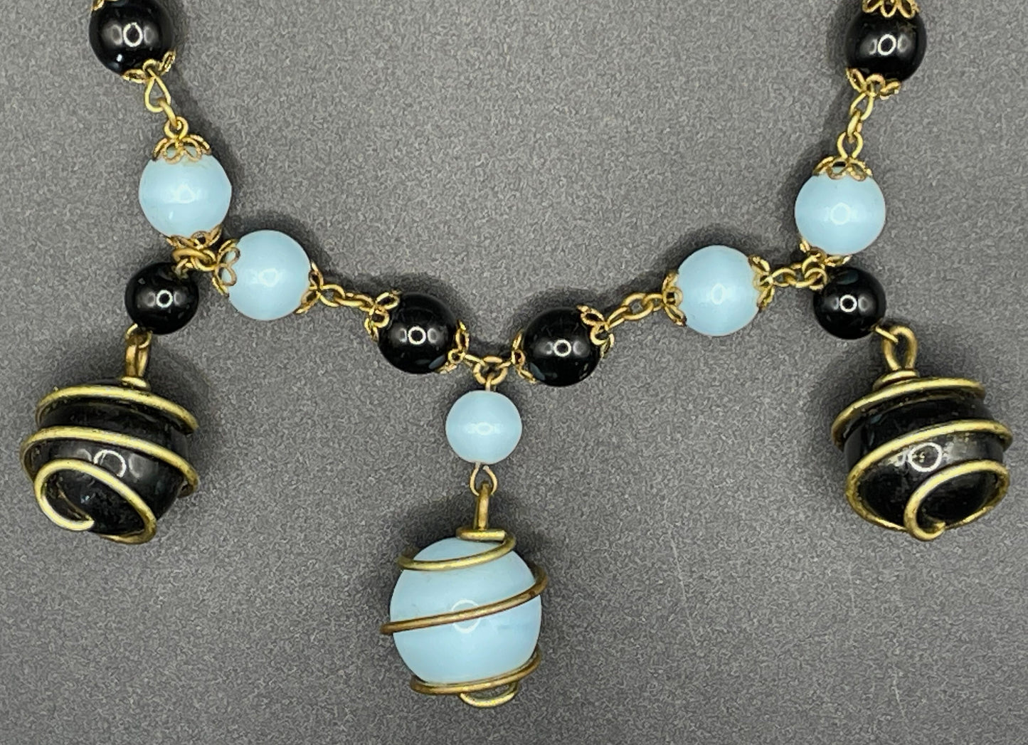 Vintage black and pale blue glass berry beaded charm necklace, gold tone wire spiral cages and filigree bead caps