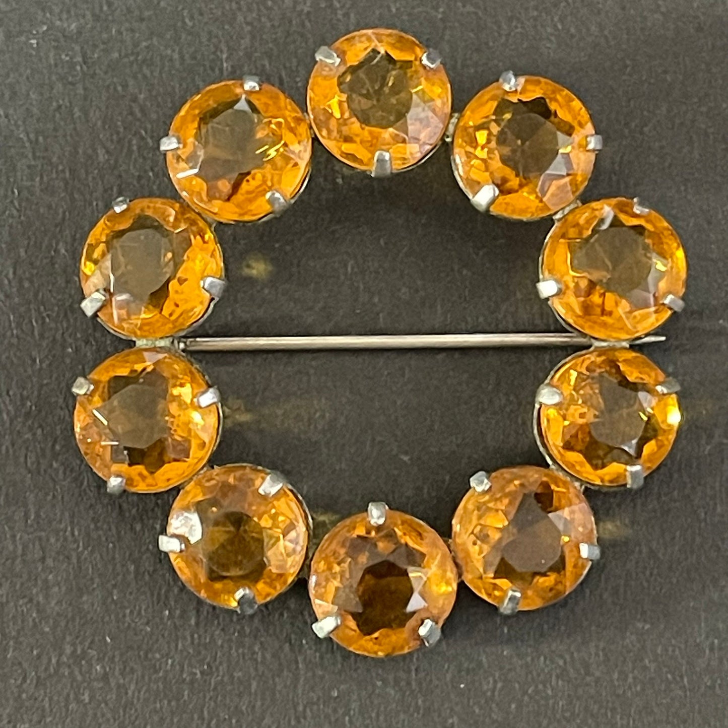 Vintage Art Deco bezel set sunshine coloured citrine yellow / orange crystal riviere circle brooch, open-backed rhinestones in silver tone