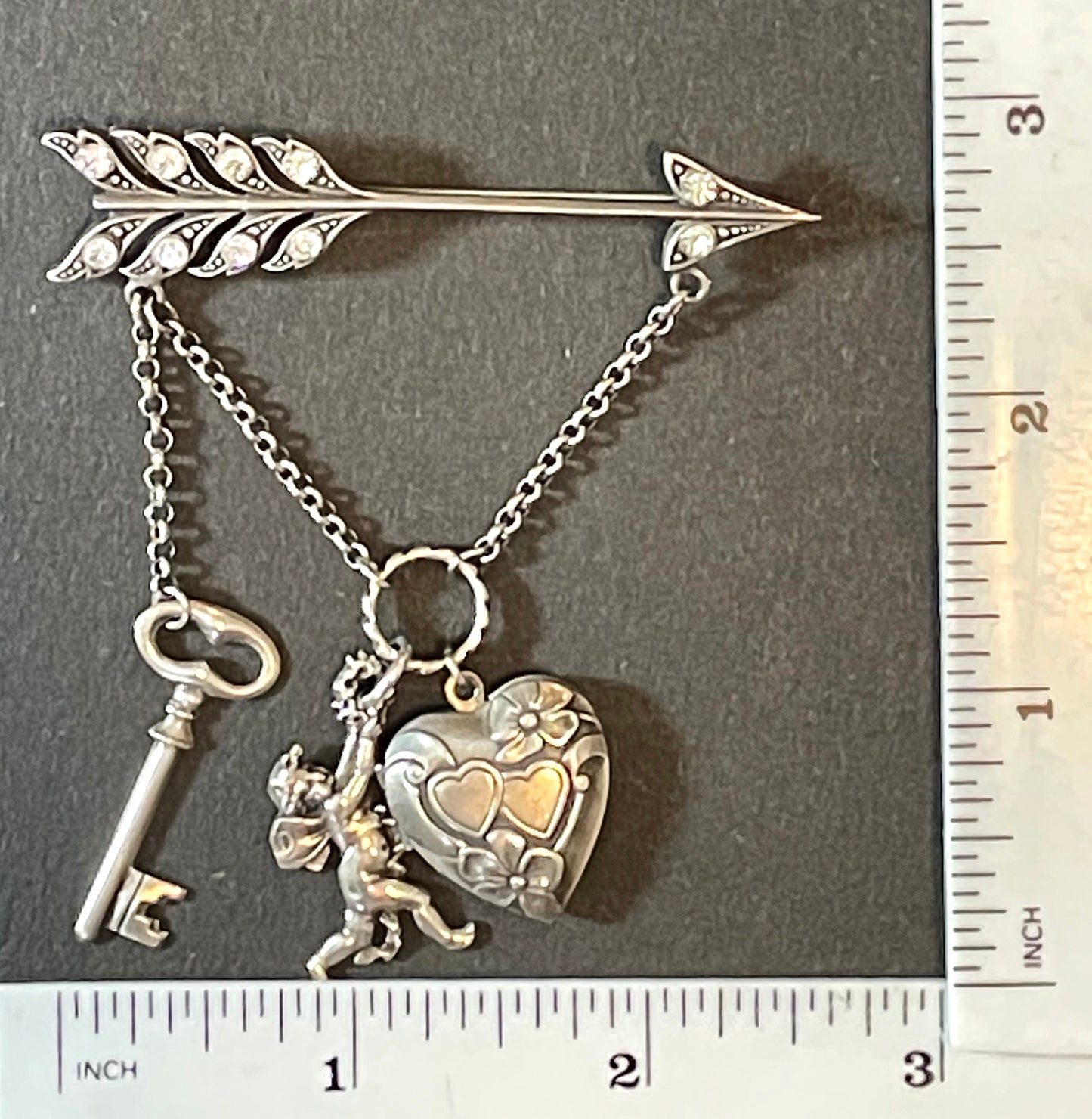 Large early Askew London, vintage cupid's arrow love brooch in antique silver tone with rhinestones, cherub, heart locket and key