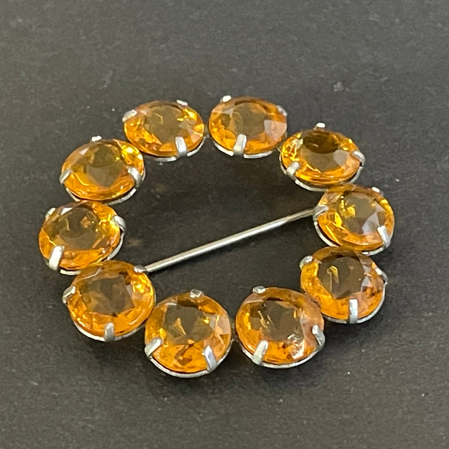 Vintage Art Deco bezel set sunshine coloured citrine yellow / orange crystal riviere circle brooch, open-backed rhinestones in silver tone