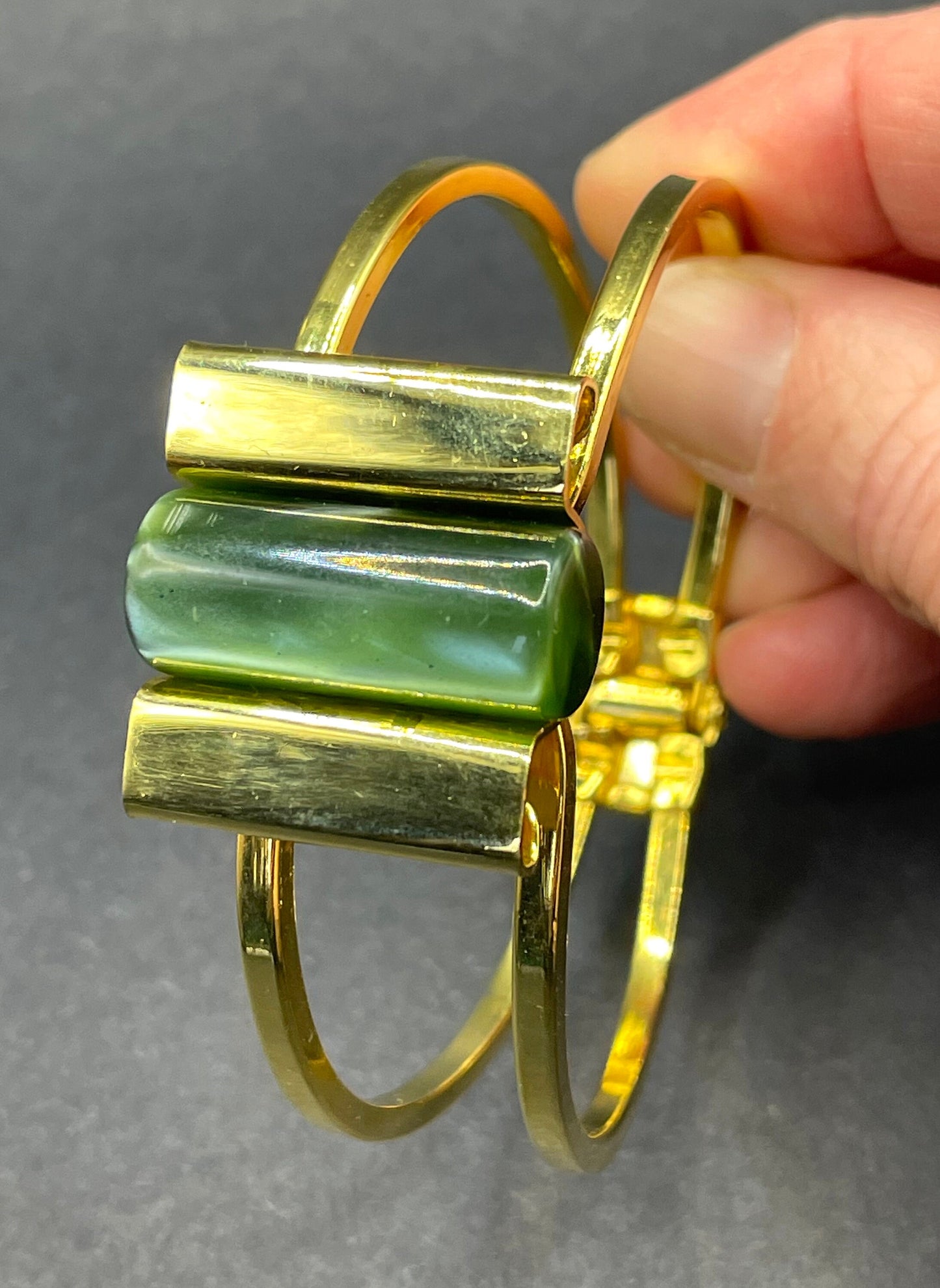 Vintage Jakob Bengel Art Deco machine age clamper bangle in shiny gold tone with a rich green galalith cylinder