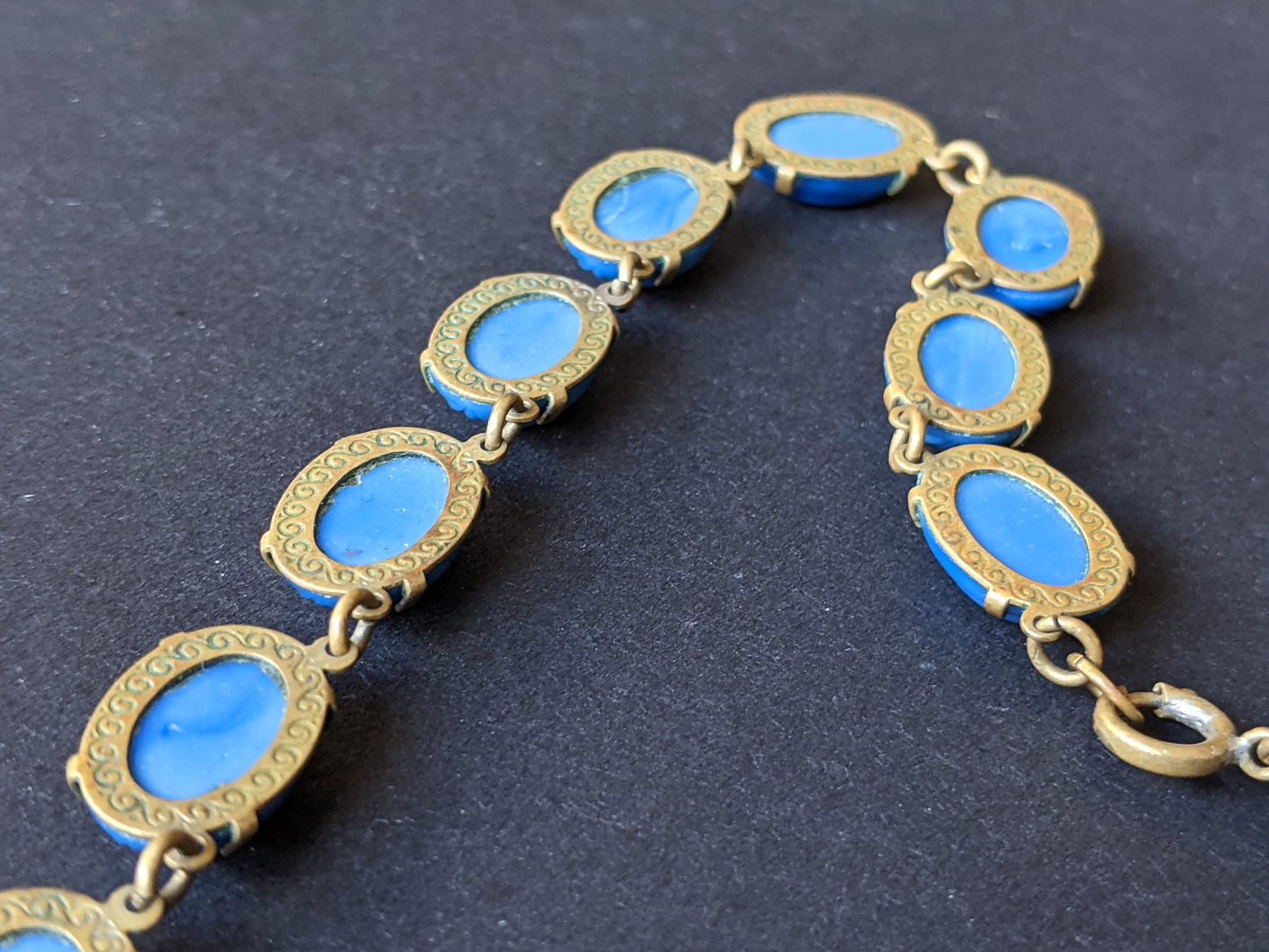 Vintage Art Deco bezel set royal blue moulded glass cabochon riviere necklace, open-backed settings in pretty engraved gold tone, 1920s-30s