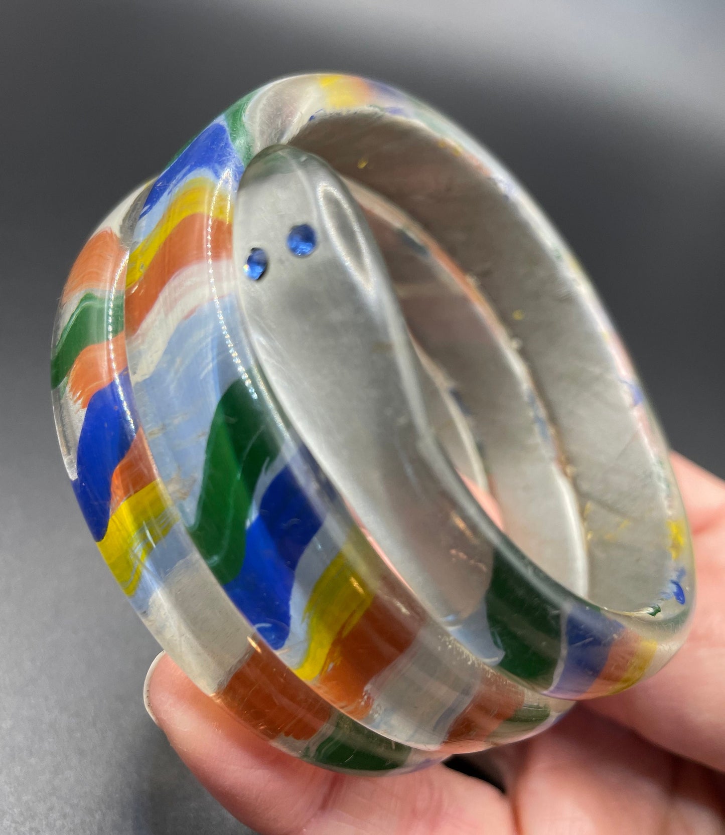 Vintage Art Deco 1920s to 1930s rainbow painted, clear celluloid spiral snake bangle bracelet, blue rhinestone eyes