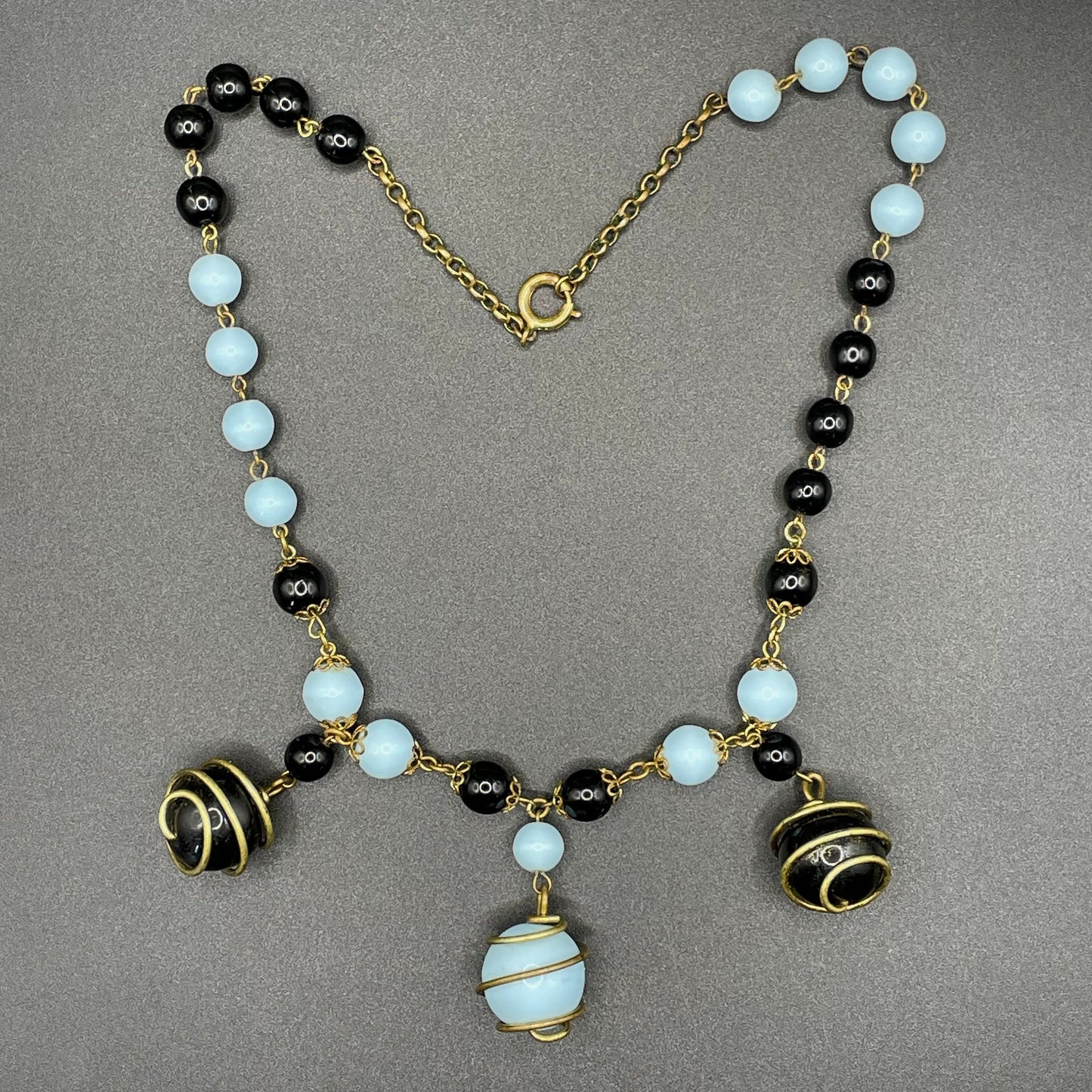 Vintage black and pale blue glass berry beaded charm necklace, gold tone wire spiral cages and filigree bead caps