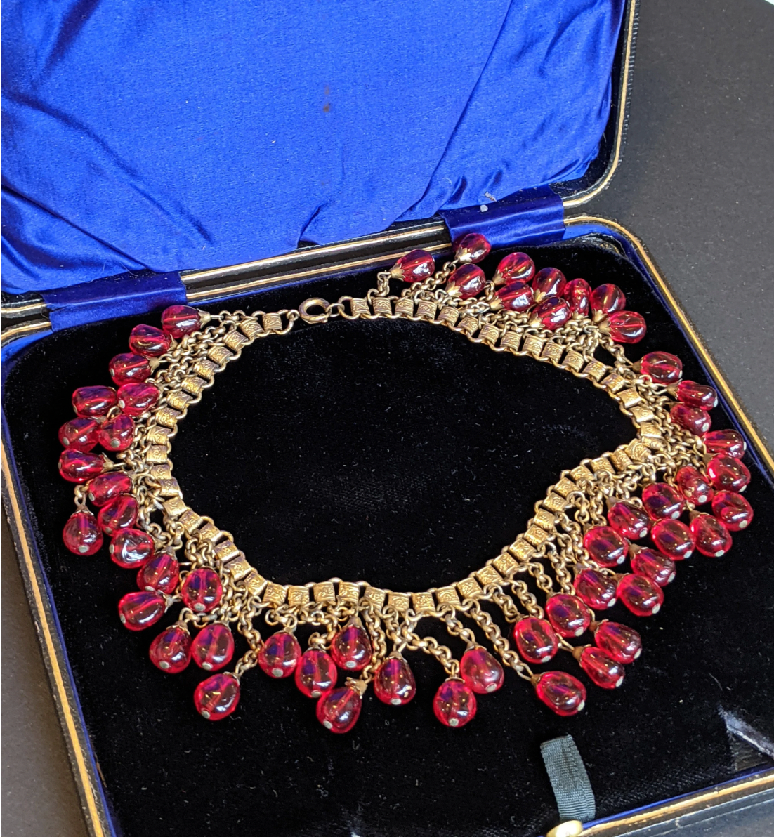 Vintage early Miriam Haskell ruby red poured glass beaded Egyptian revival fringe necklace with gold tone book chain - in box