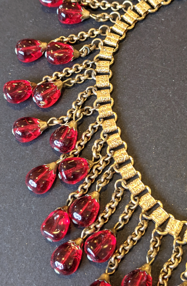 Vintage early Miriam Haskell ruby red poured glass beaded Egyptian revival fringe necklace with gold tone book chain - in box