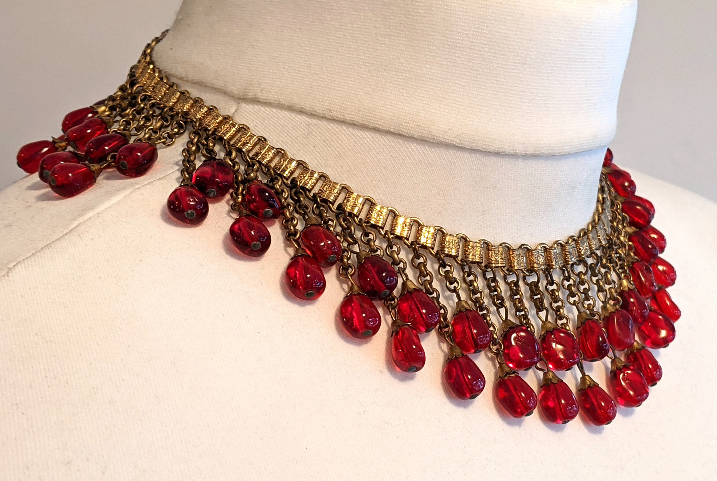 Vintage early Miriam Haskell ruby red poured glass beaded Egyptian revival fringe necklace with gold tone book chain - in box