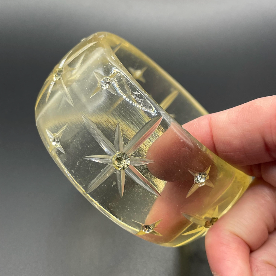 Vintage apple juice coloured transparent plastic wide, engraved bangle, studded with clear glass rhinestones, Art Deco style