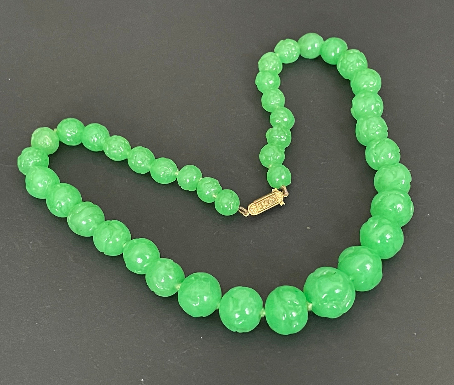 Vintage bright green jade coloured moulded glass graduated bead necklace, hand-knotted with gold tone fish hook clasp