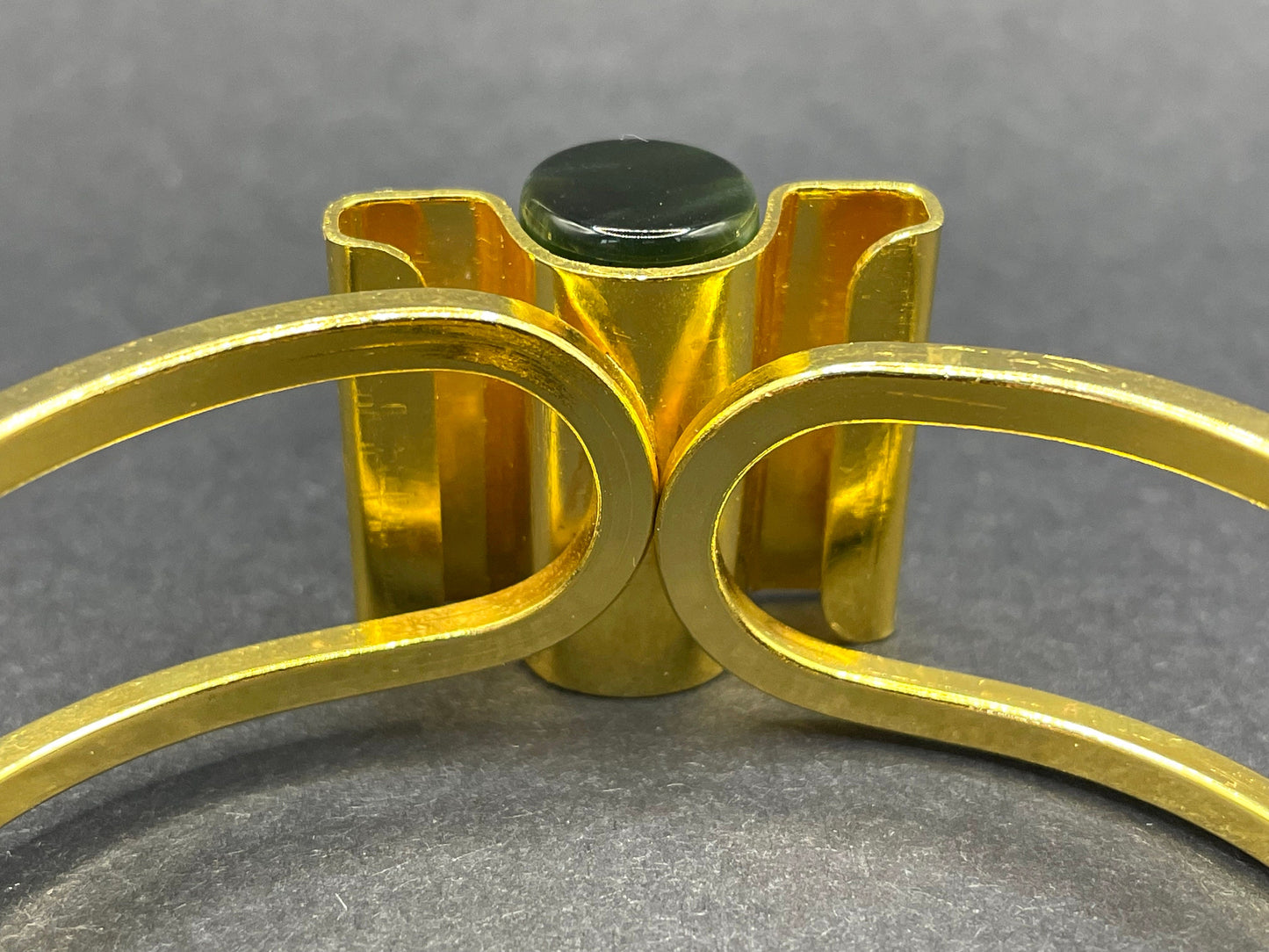 Vintage Jakob Bengel Art Deco machine age clamper bangle in shiny gold tone with a rich green galalith cylinder