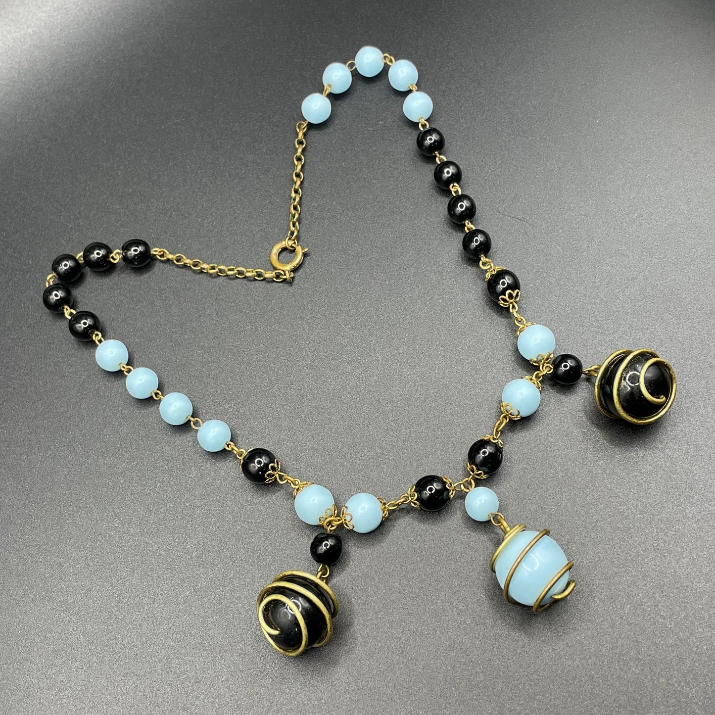 Vintage black and pale blue glass berry beaded charm necklace, gold tone wire spiral cages and filigree bead caps