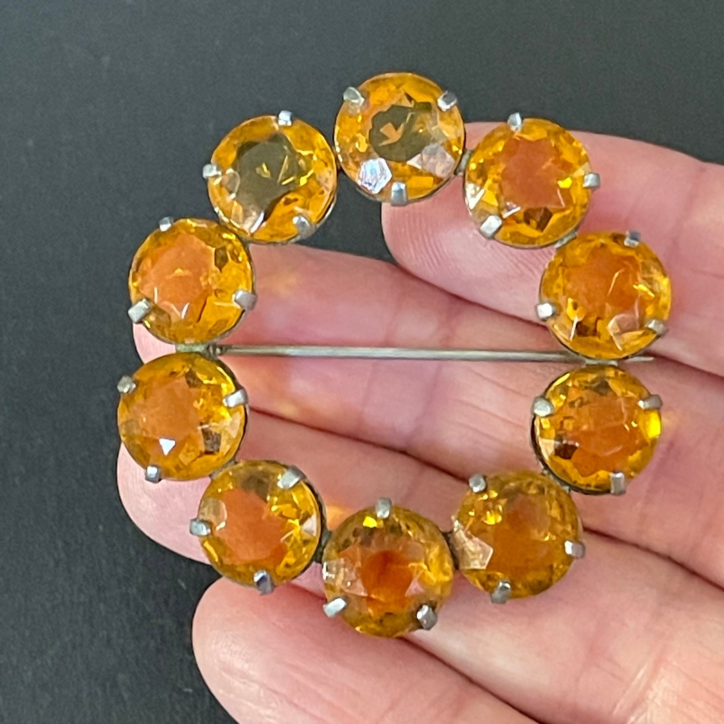 Vintage Art Deco bezel set sunshine coloured citrine yellow / orange crystal riviere circle brooch, open-backed rhinestones in silver tone