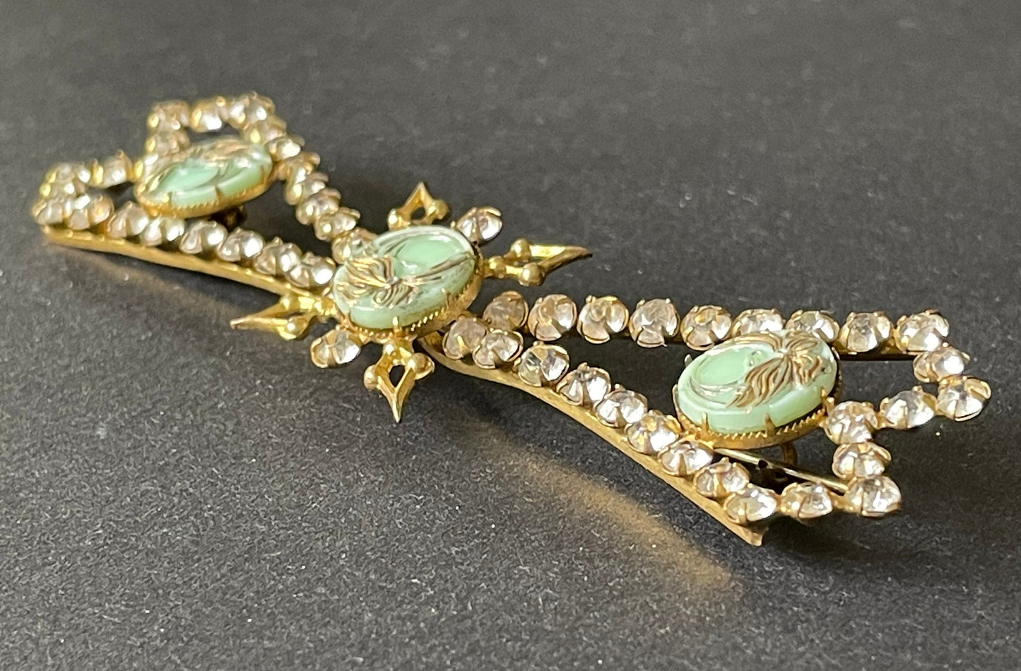 Huge vintage paste brooch, clear rhinestones with moulded green glass floral discs, gold tone closed cup settings, Deco geometric bow design