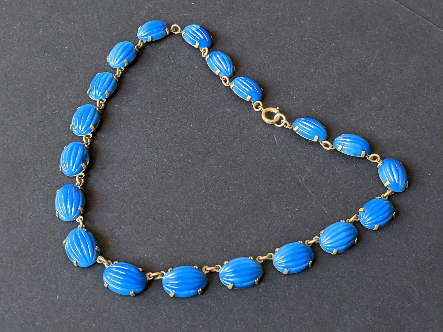 Vintage Art Deco bezel set royal blue moulded glass cabochon riviere necklace, open-backed settings in pretty engraved gold tone, 1920s-30s