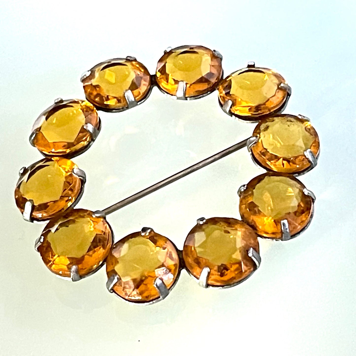 Vintage Art Deco bezel set sunshine coloured citrine yellow / orange crystal riviere circle brooch, open-backed rhinestones in silver tone