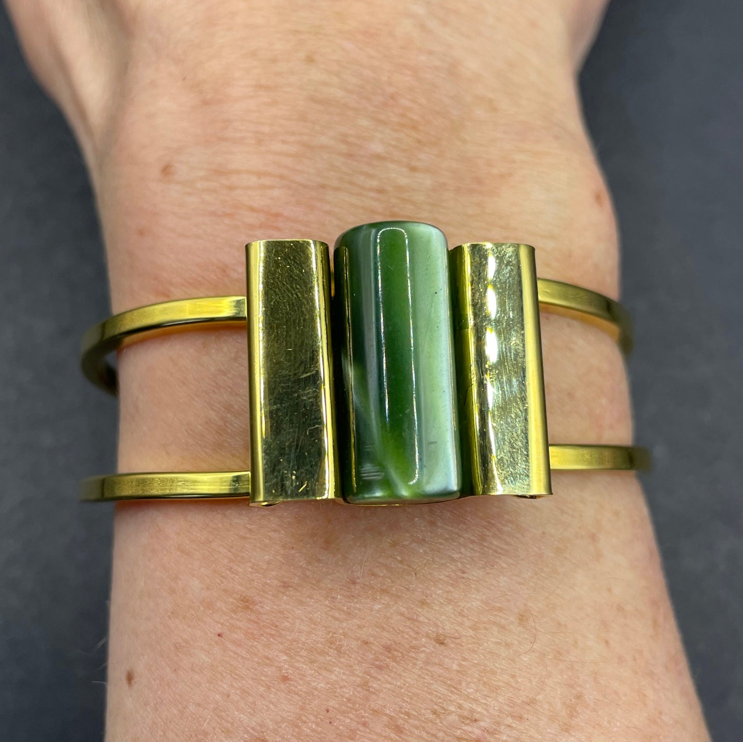 Vintage Jakob Bengel Art Deco machine age clamper bangle in shiny gold tone with a rich green galalith cylinder