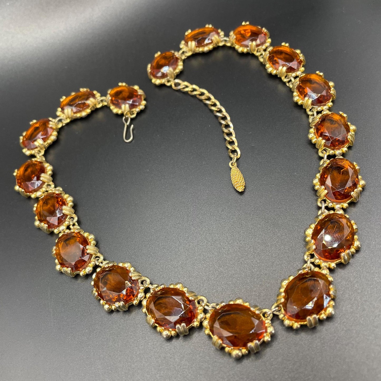 Vintage bright orange topaz / citrine yellow riviere necklace, made by Sphinx, bezel set, open-backed stones in ornate gold tone setting