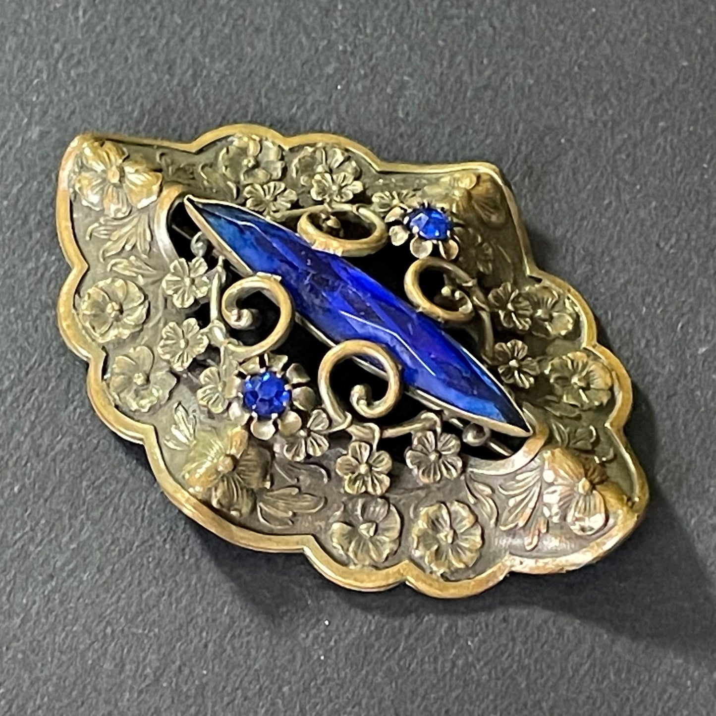 Large vintage Art Nouveau to Art Deco sapphire blue rhinestone & ornate gold tone three dimensional floral design Czech brooch, Neiger style