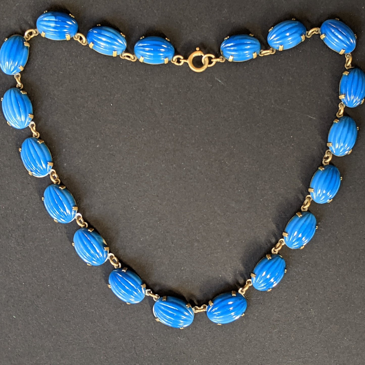 Vintage Art Deco bezel set royal blue moulded glass cabochon riviere necklace, open-backed settings in pretty engraved gold tone, 1920s-30s