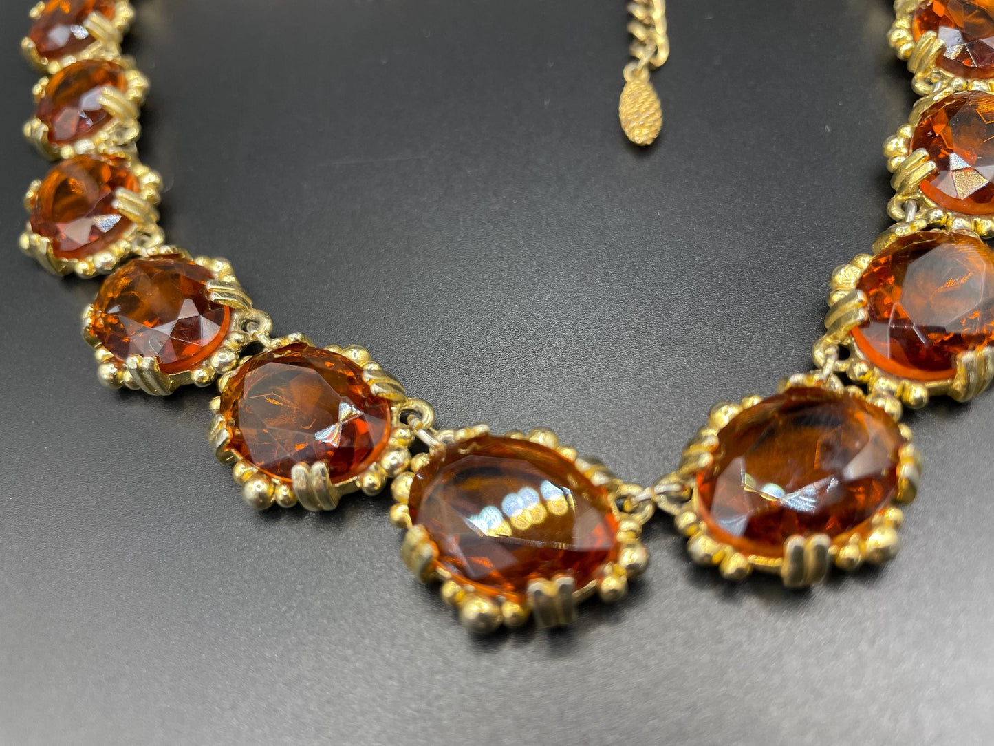 Vintage bright orange topaz / citrine yellow riviere necklace, made by Sphinx, bezel set, open-backed stones in ornate gold tone setting